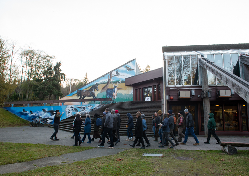 A group of people walking past a staircase next to a building.