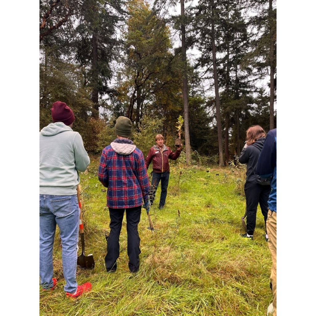 A person talking about planting practices to a group of people.