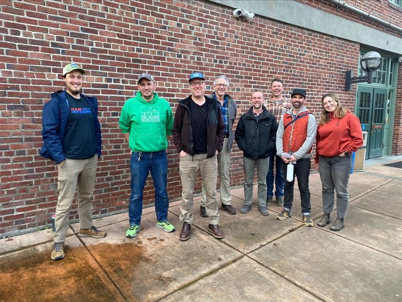 A group photo of the DNDA pilot group in front of a brick building.